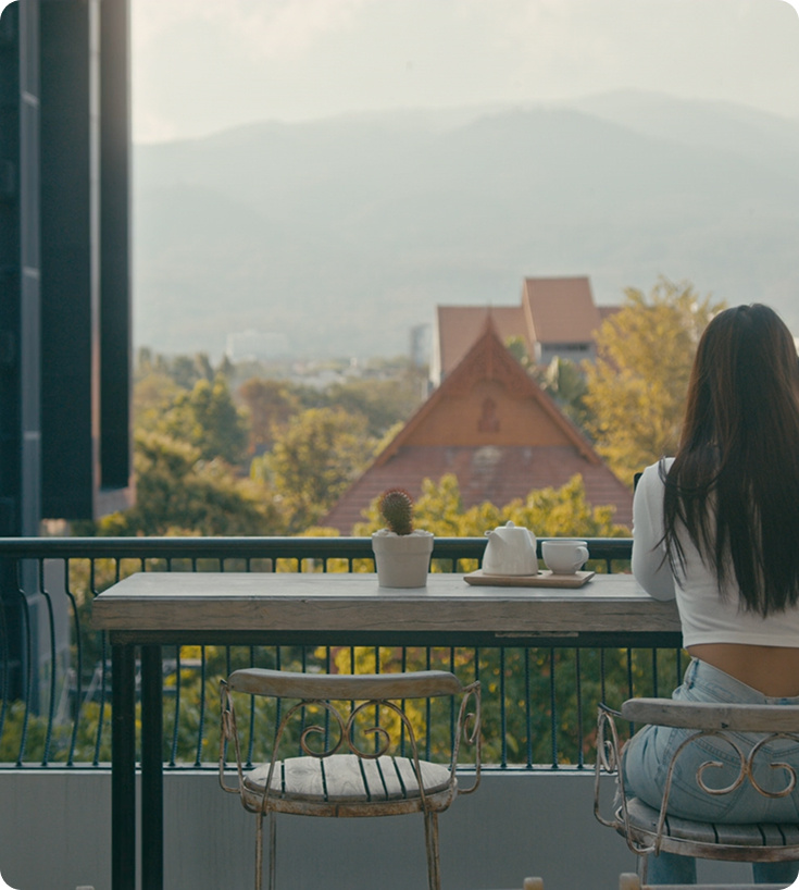 Femme assise sur un balcon.