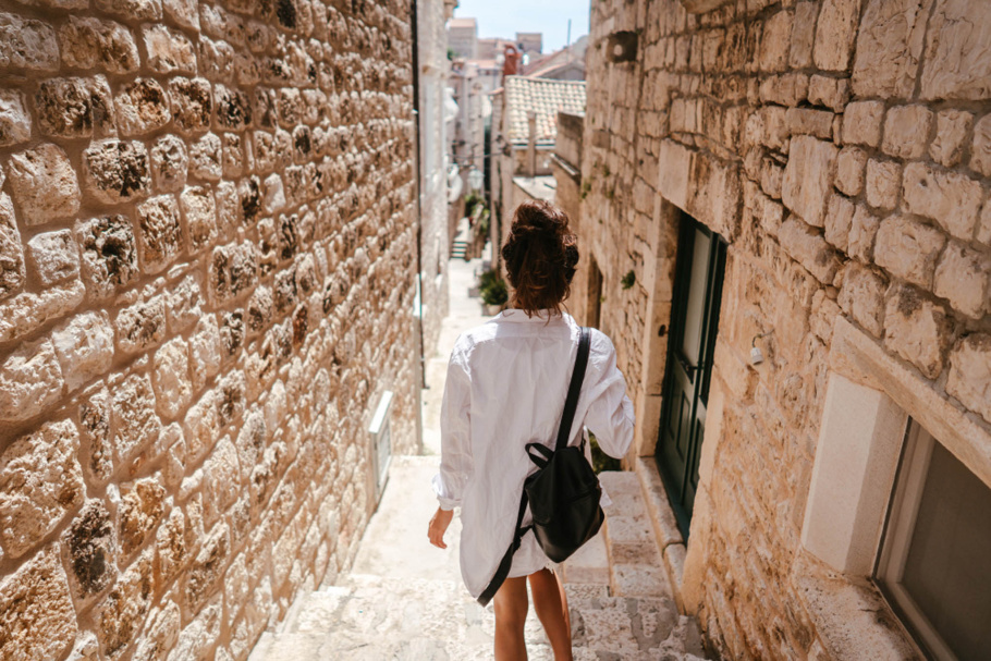 Person walking through a cobblestone alley.