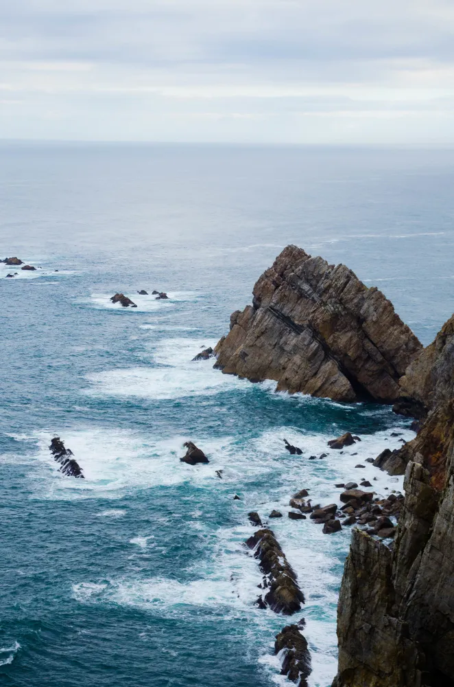 Rochers escarpés dans l'océan agité.