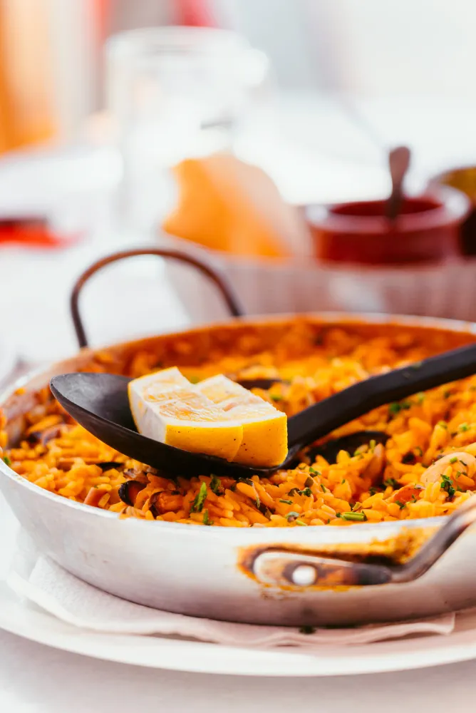 Paella with lemon in a pan.