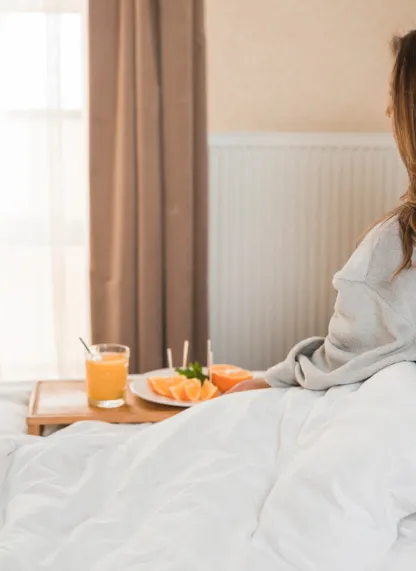 Mujer con un desayuno en la cama.