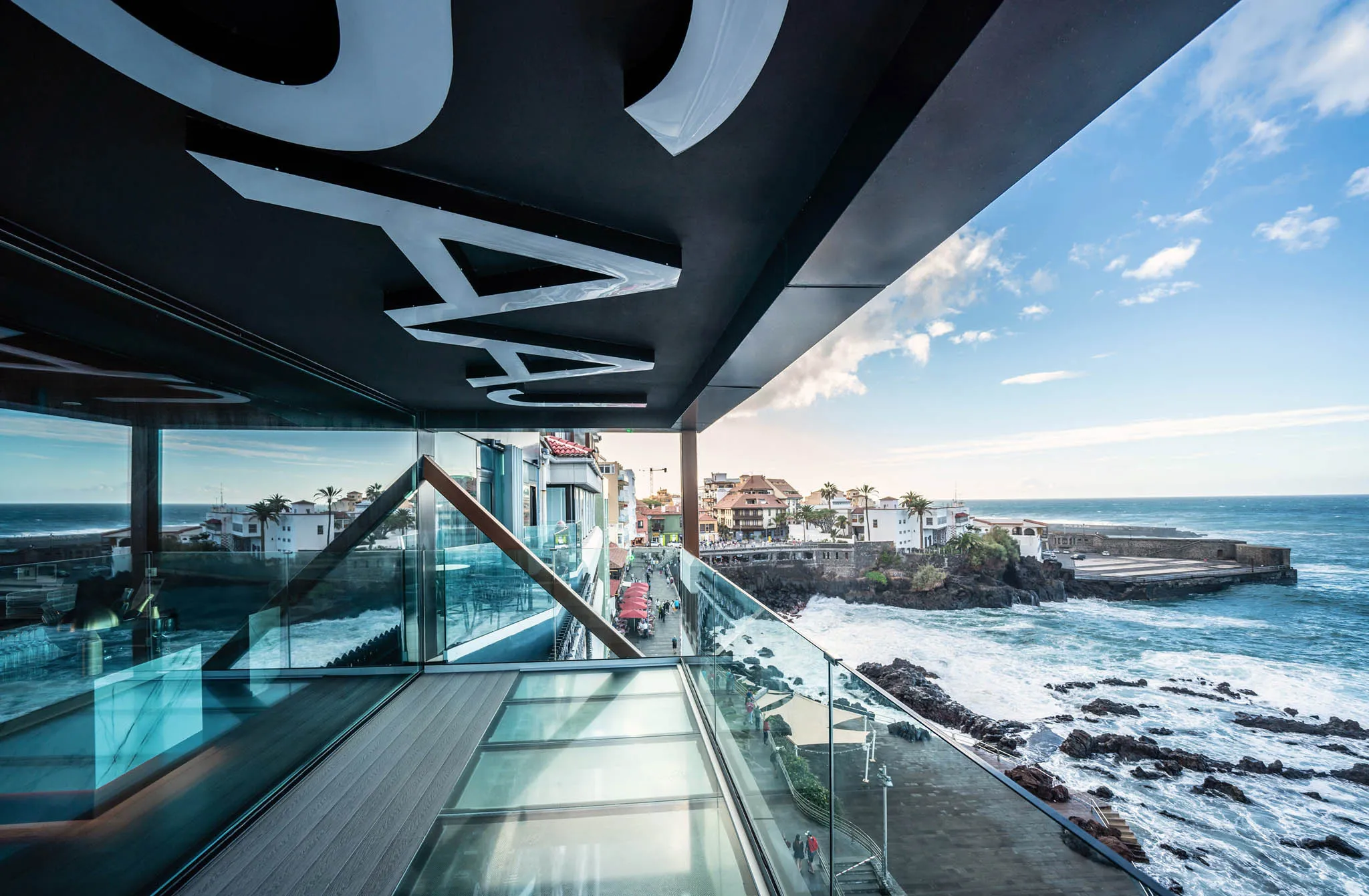 Glass terrace with coastal view.