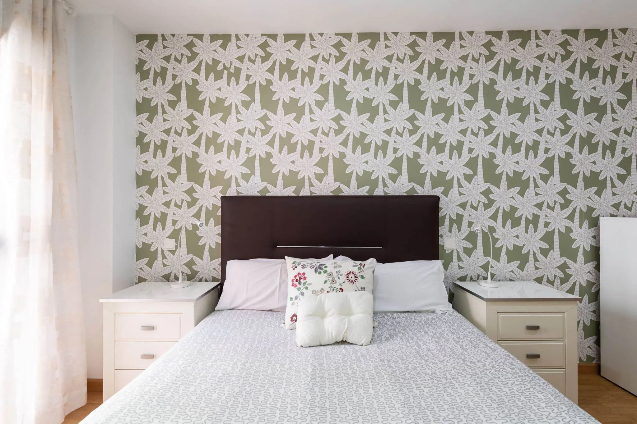 Chambre avec papier peint floral vert.