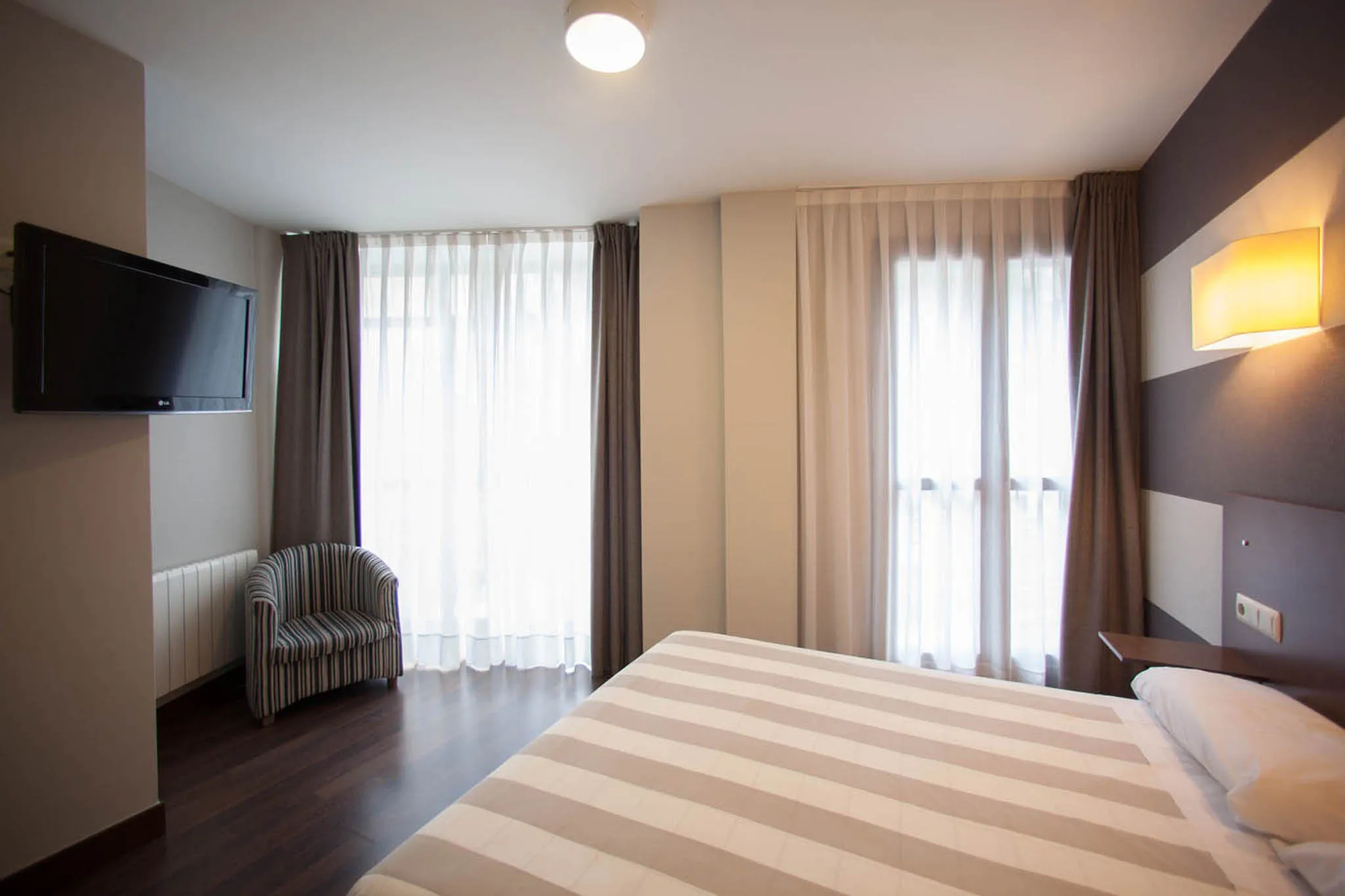 Habitación moderna con cama y televisión.