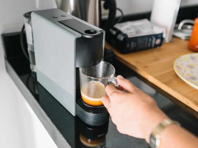 Personne servant du café d'une machine automatique.