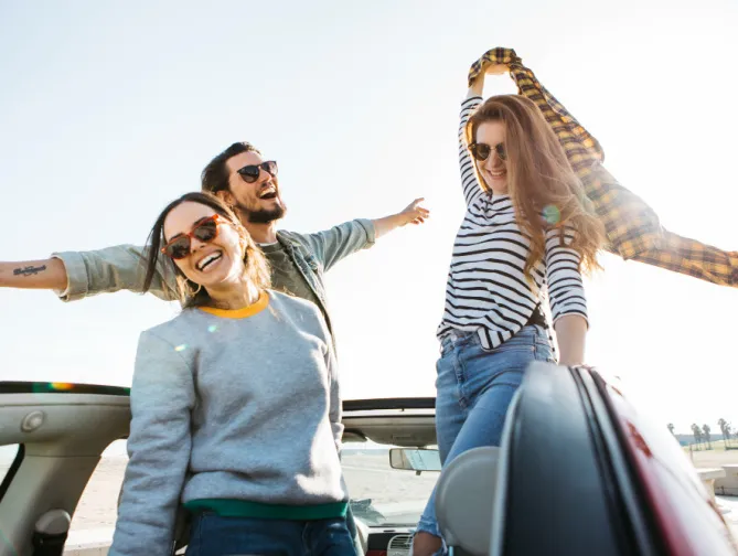 Personnes heureuses en voiture décapotable.